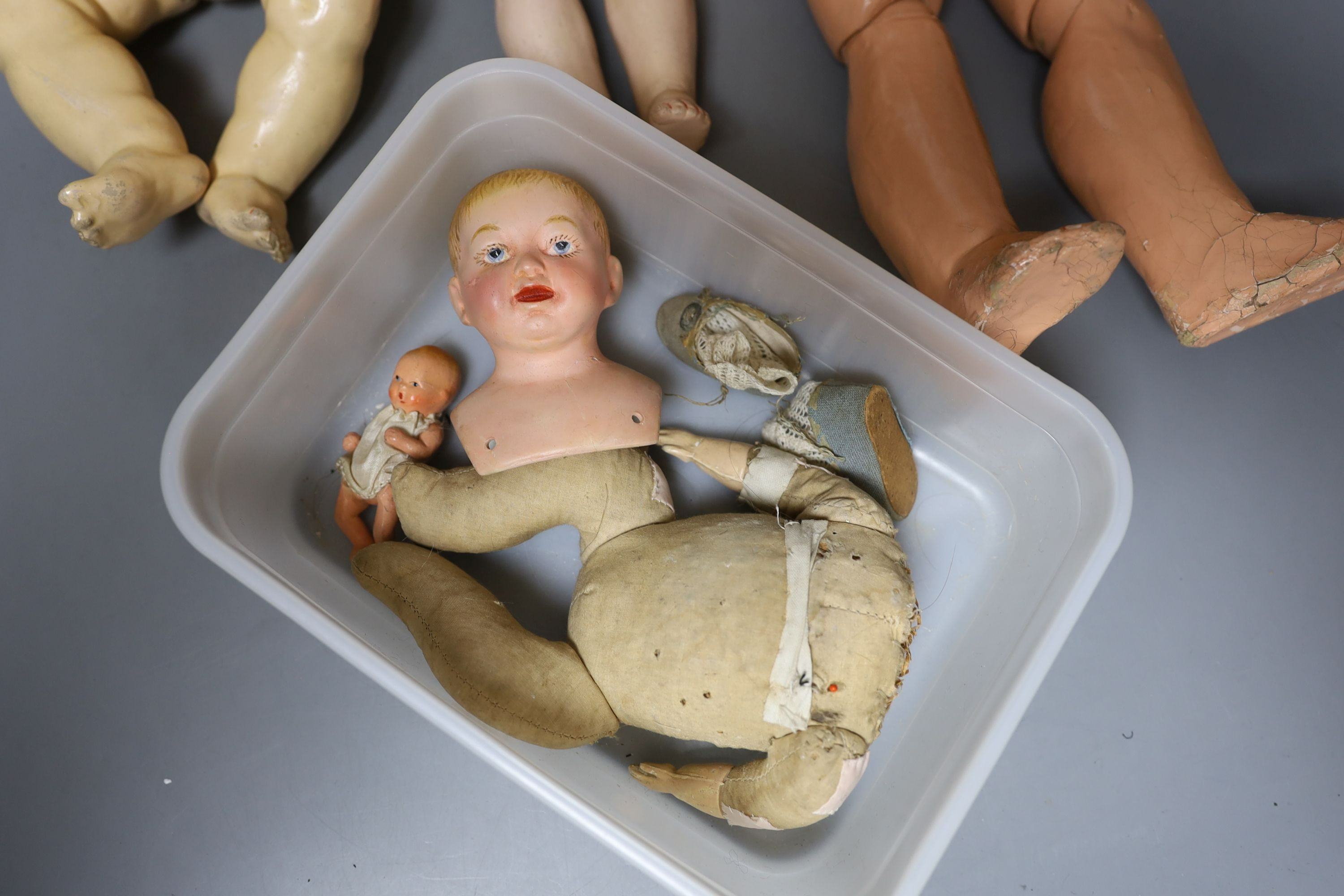 A kid leather bodied jointed limb open mouth Heubach bisque headed doll together with two other bisque headed dolls and a boy doll (damaged)